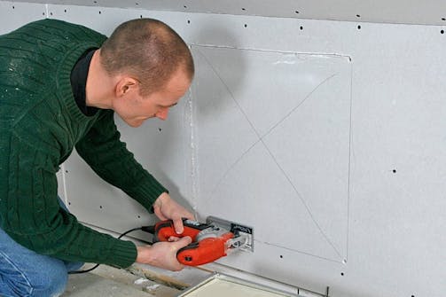 Stiksav: Sav hul til en lem i gipsvæggen med en stiksav Stiksav: Sav hul til en lem i gipsvæggen med en stiksav